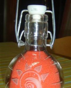 Incisione su bottiglia di vetro, con disegno sole stilizzato