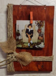 Portafoto in legno, con fiocco in corda e cordoncino incrociato.